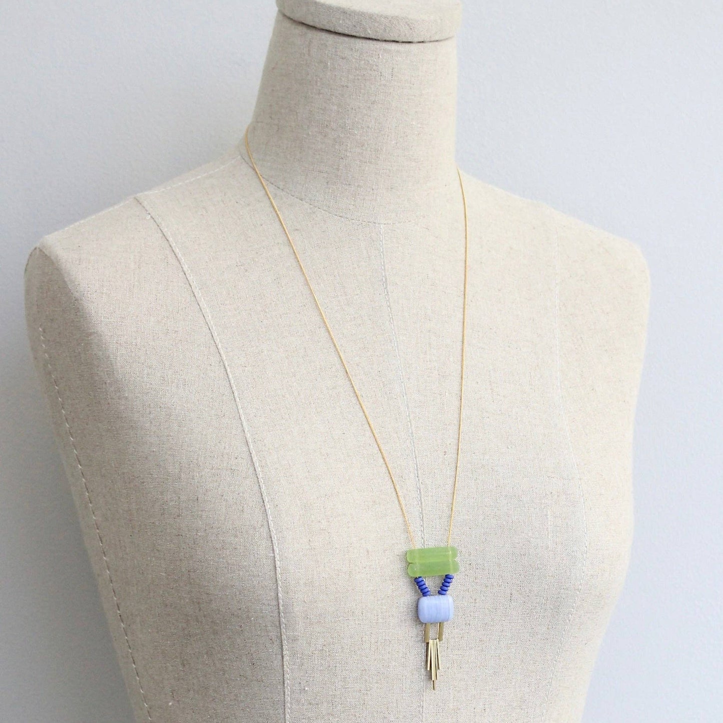 Necklace with a pendant on a mannequin against a light gray background