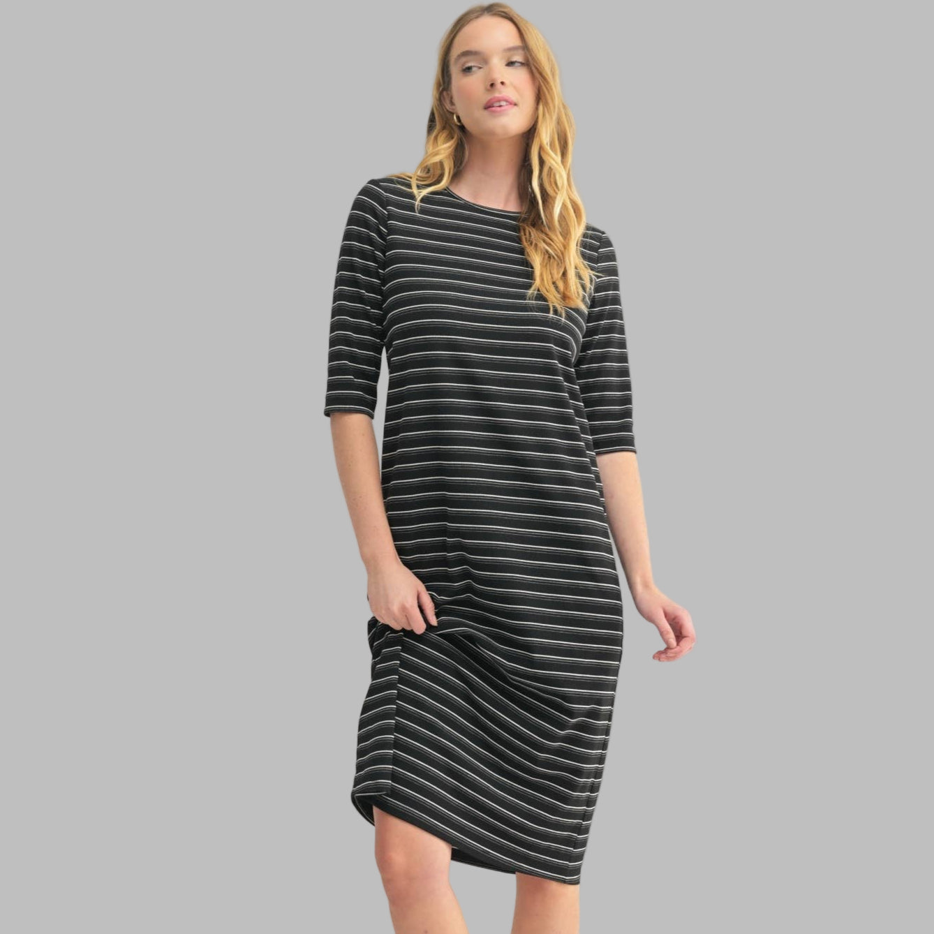 Woman wearing a black and white striped dress on a white background