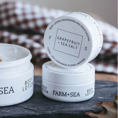Farm + Sea skincare products on a wooden surface with a checkered cloth in the background.