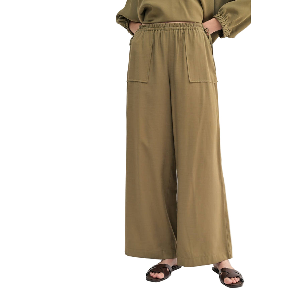 Person wearing olive green wide-leg pants on a white background