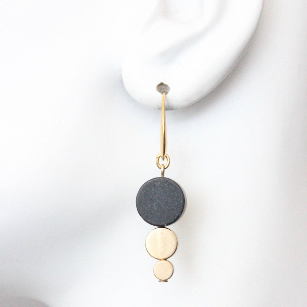 Earring with three circular pendants on a white background