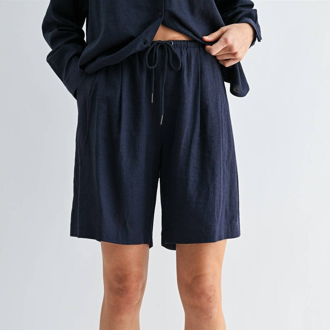 Person wearing navy shorts on a white background