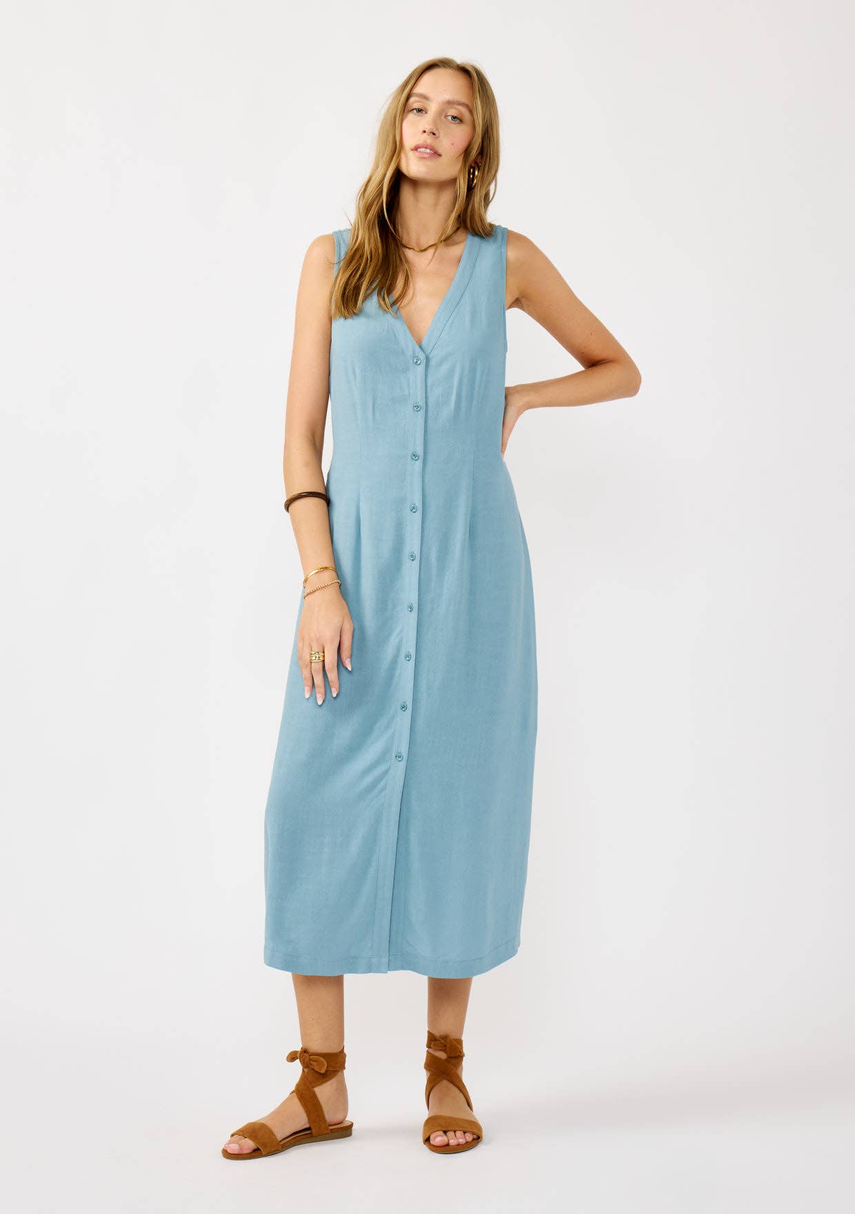 Woman wearing a light blue sleeveless dress on a white background