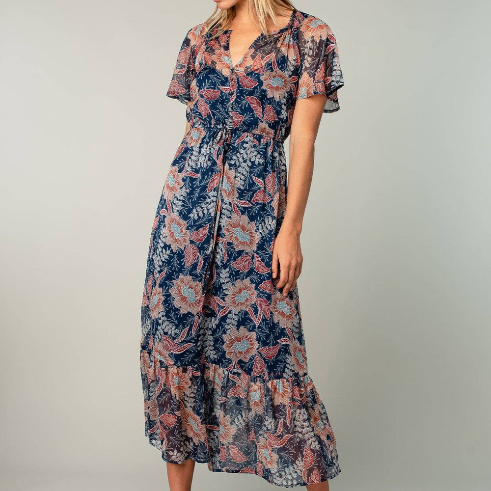 
                      
                        Woman wearing a floral dress on a plain background
                      
                    