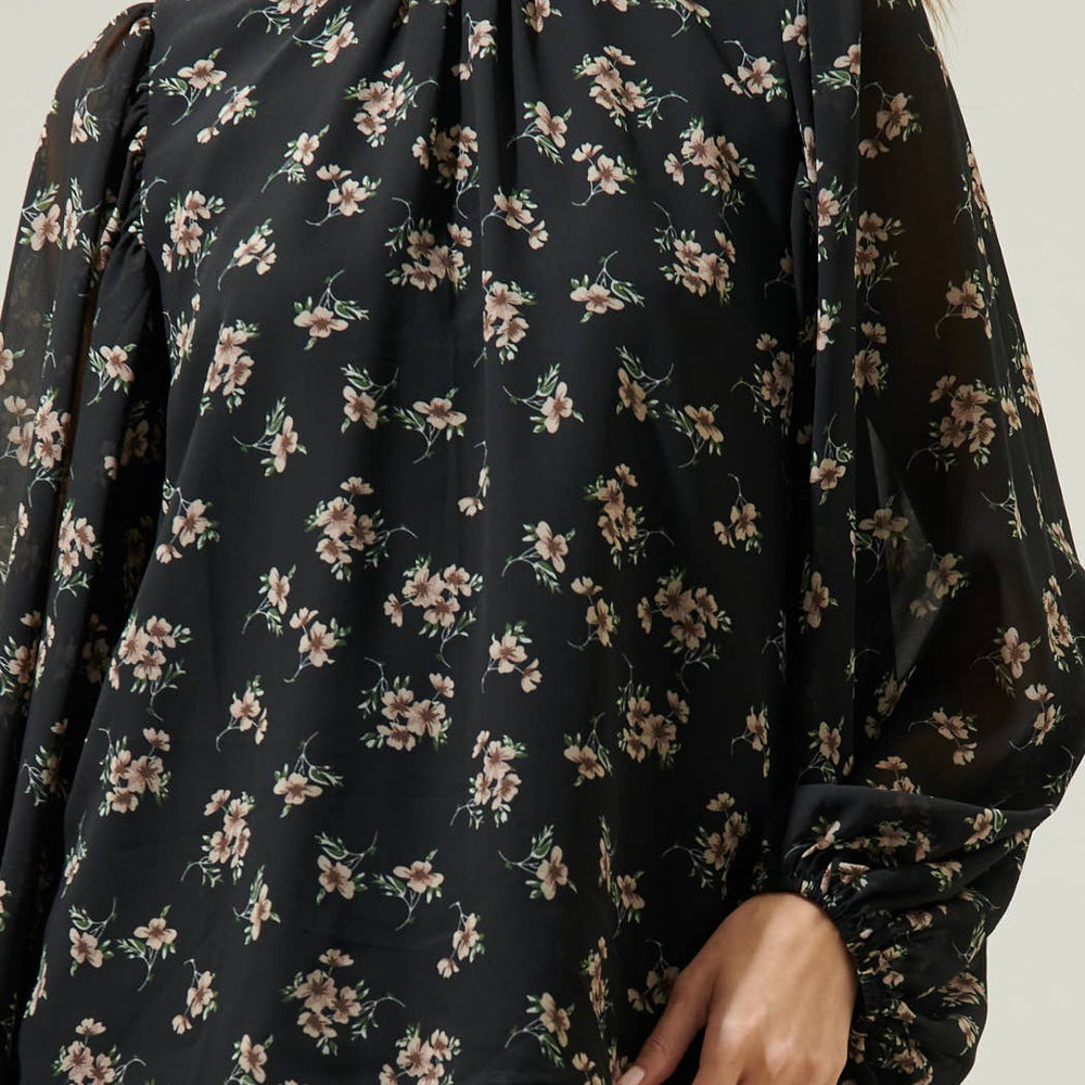 
                      
                        Black floral blouse worn by a person on a neutral background
                      
                    