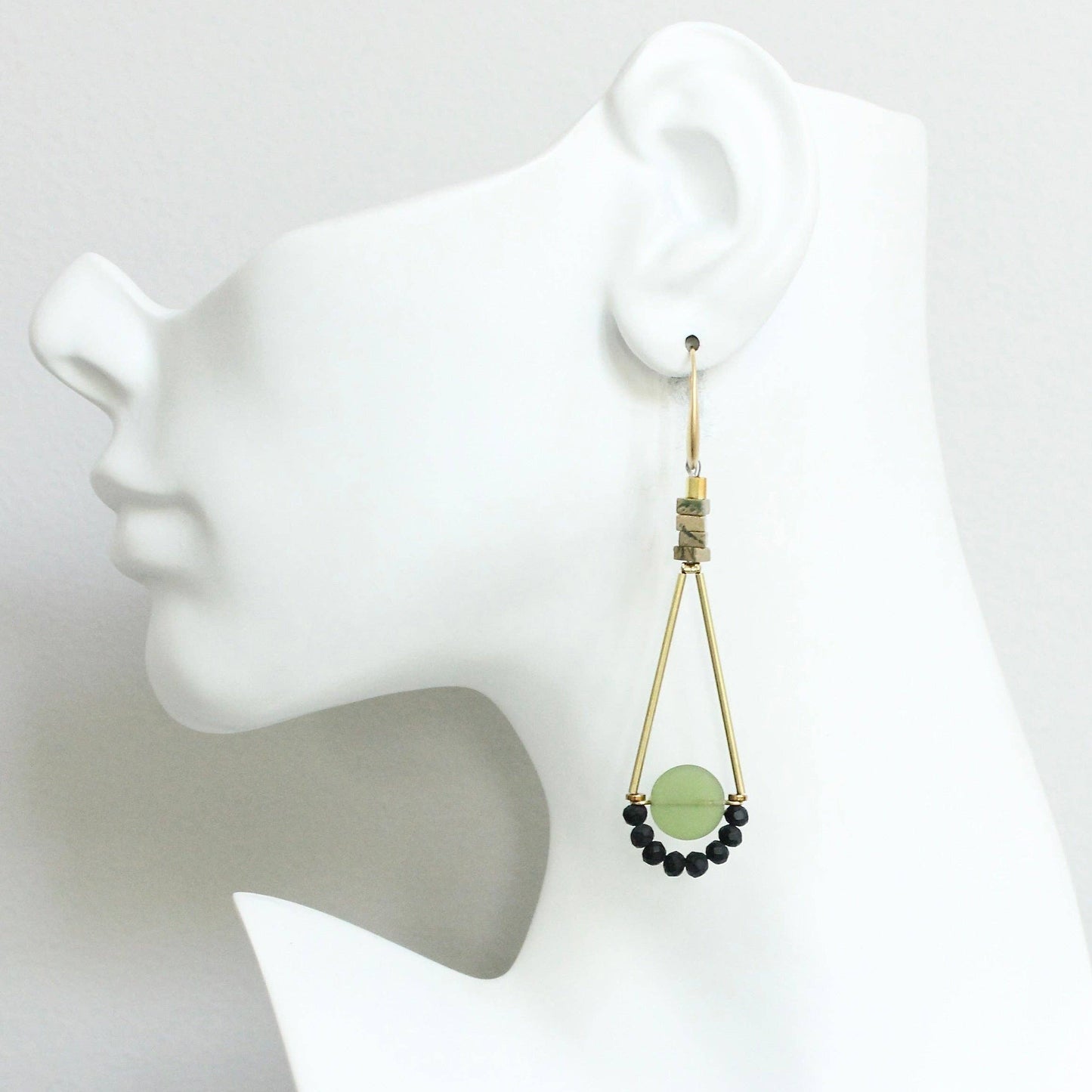 Earring on a mannequin ear with a white background
