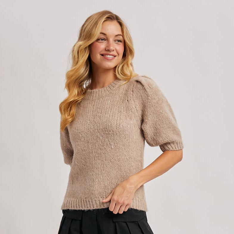 
                      
                        Woman wearing a beige sweater and black wide-leg pants on a plain background
                      
                    