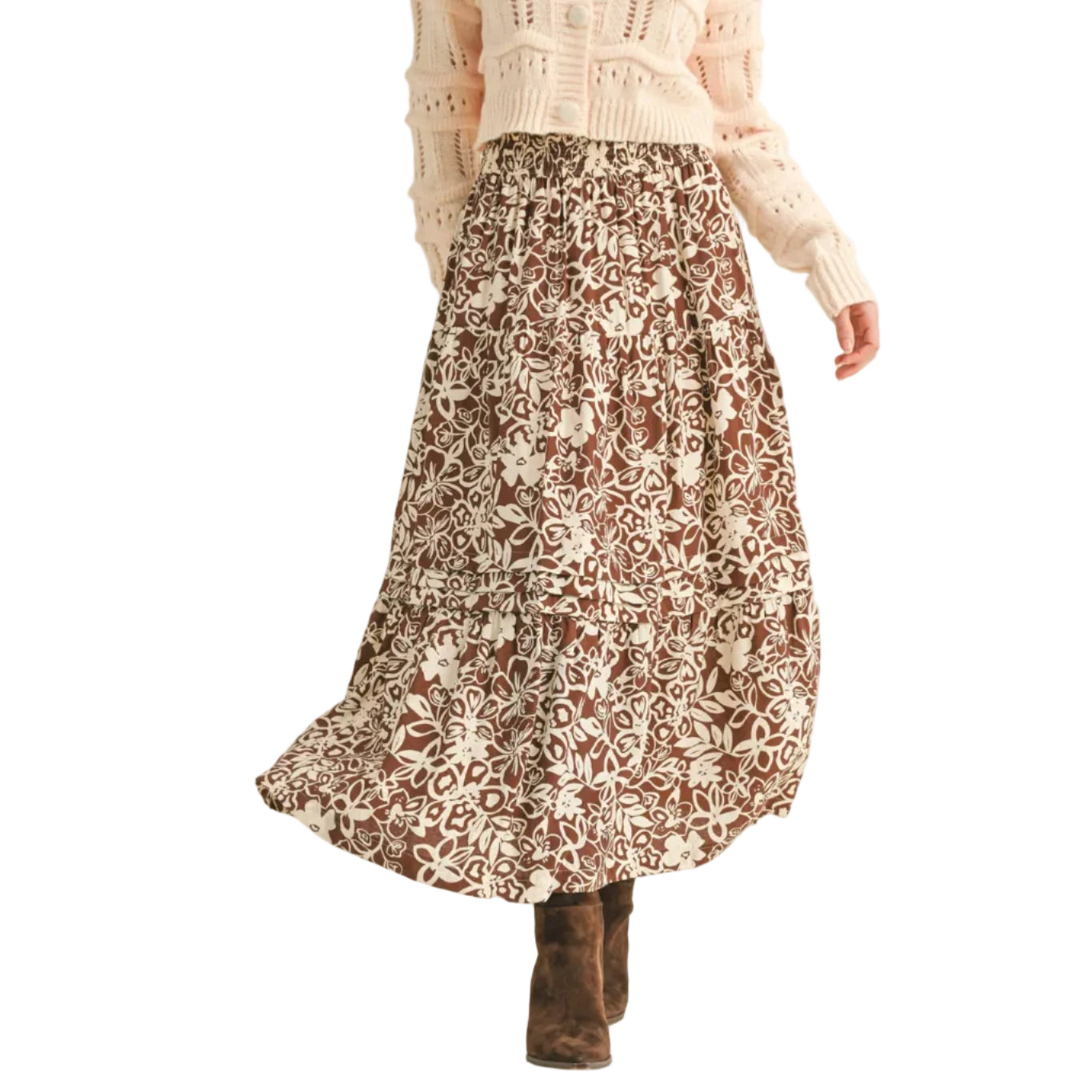 Woman wearing a floral skirt and light sweater on a beige background
