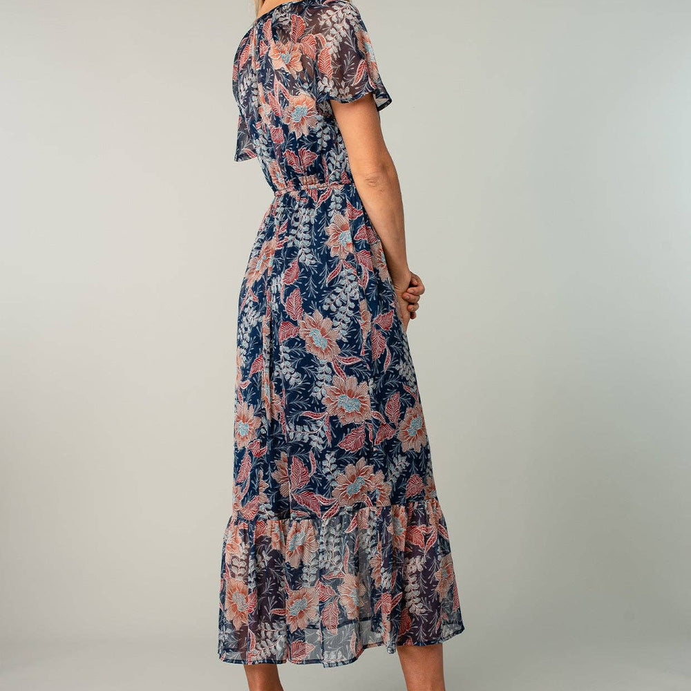 
                      
                        Woman wearing a floral dress on a plain background
                      
                    