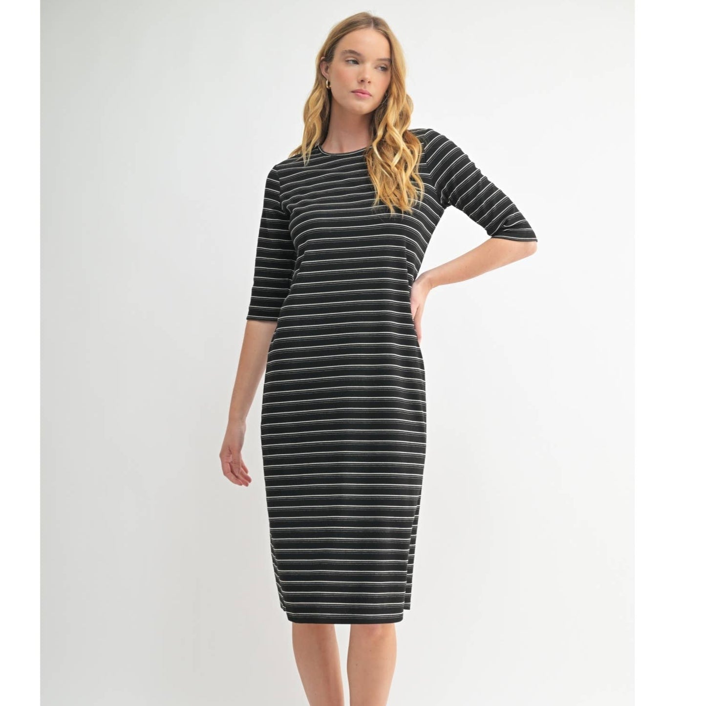 Woman wearing a black and gray striped dress on a white background