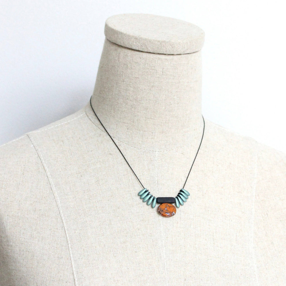 Necklace with a pendant on a mannequin bust against a white background