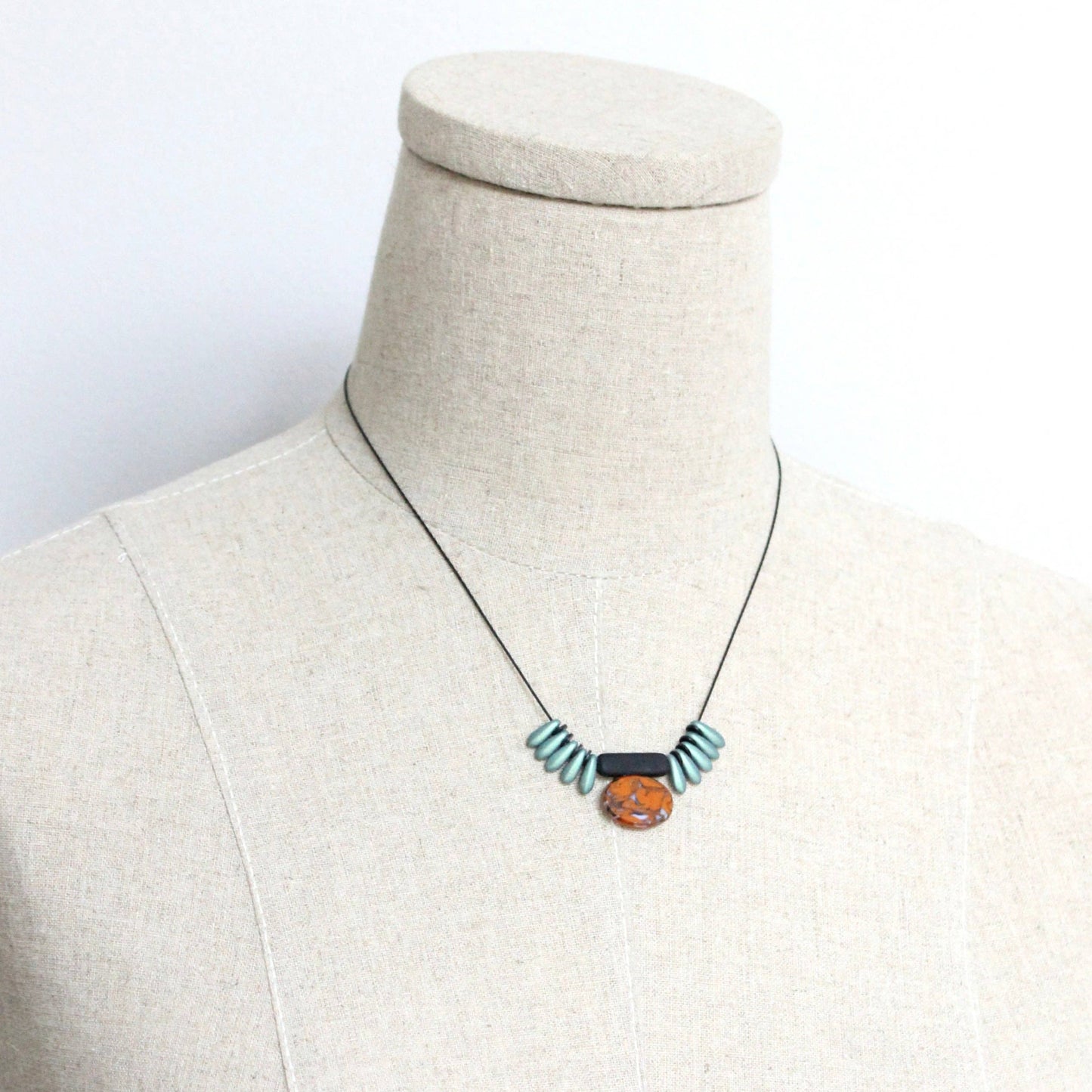 Necklace with a pendant on a mannequin bust against a white background